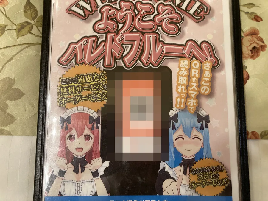 ベッドの上のメニュー表紙。QRコードを読み込む
